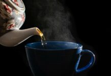 a shot of tea pouring in blue mug