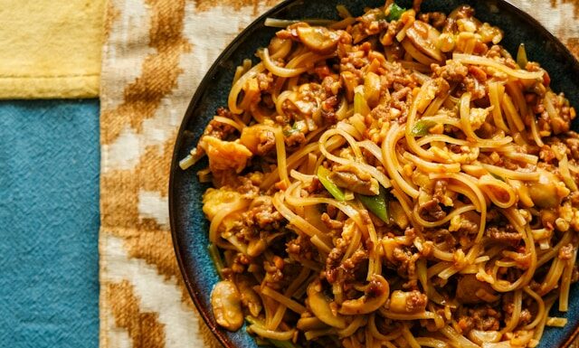 A plate of noodles and meat on a table