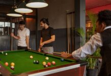 Late-Night Snooker Places in Karachi You’ll Love Three friends playing pool in a relaxed indoor setting, socializing and enjoying leisure time.