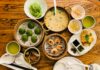 a wooden table topped with bowls of food