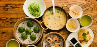 a wooden table topped with bowls of food
