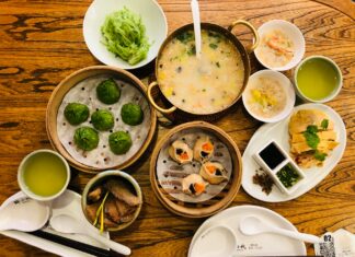 a wooden table topped with bowls of food