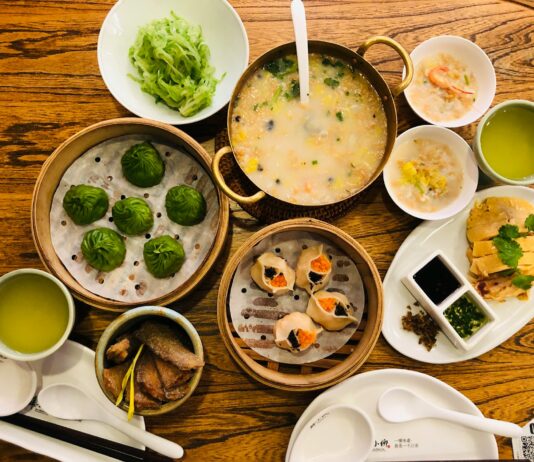 a wooden table topped with bowls of food