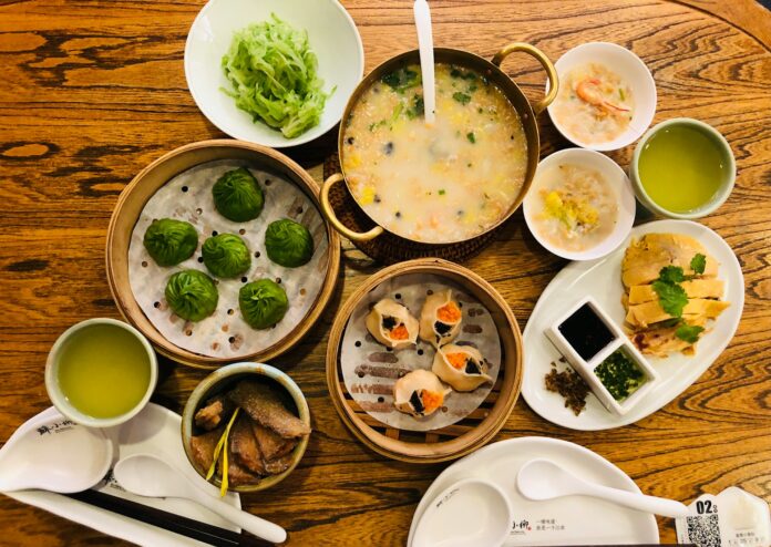 a wooden table topped with bowls of food